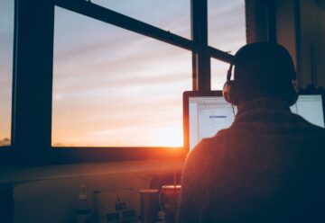 man sitting facing monitor