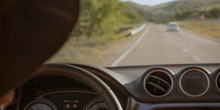 person driving car on road during daytime